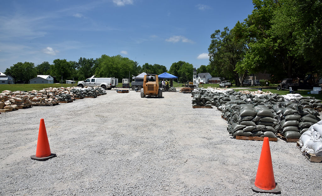Volunteers organize stacks of sandbags onto wooden pallets